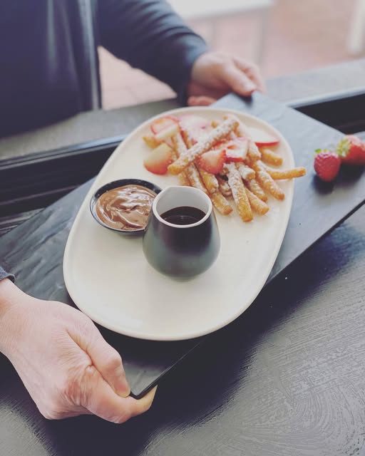 Churros with strawberries, chocolate sauce and dulce de leche on a slate tray at Numero Uno Pizza and Pasta.